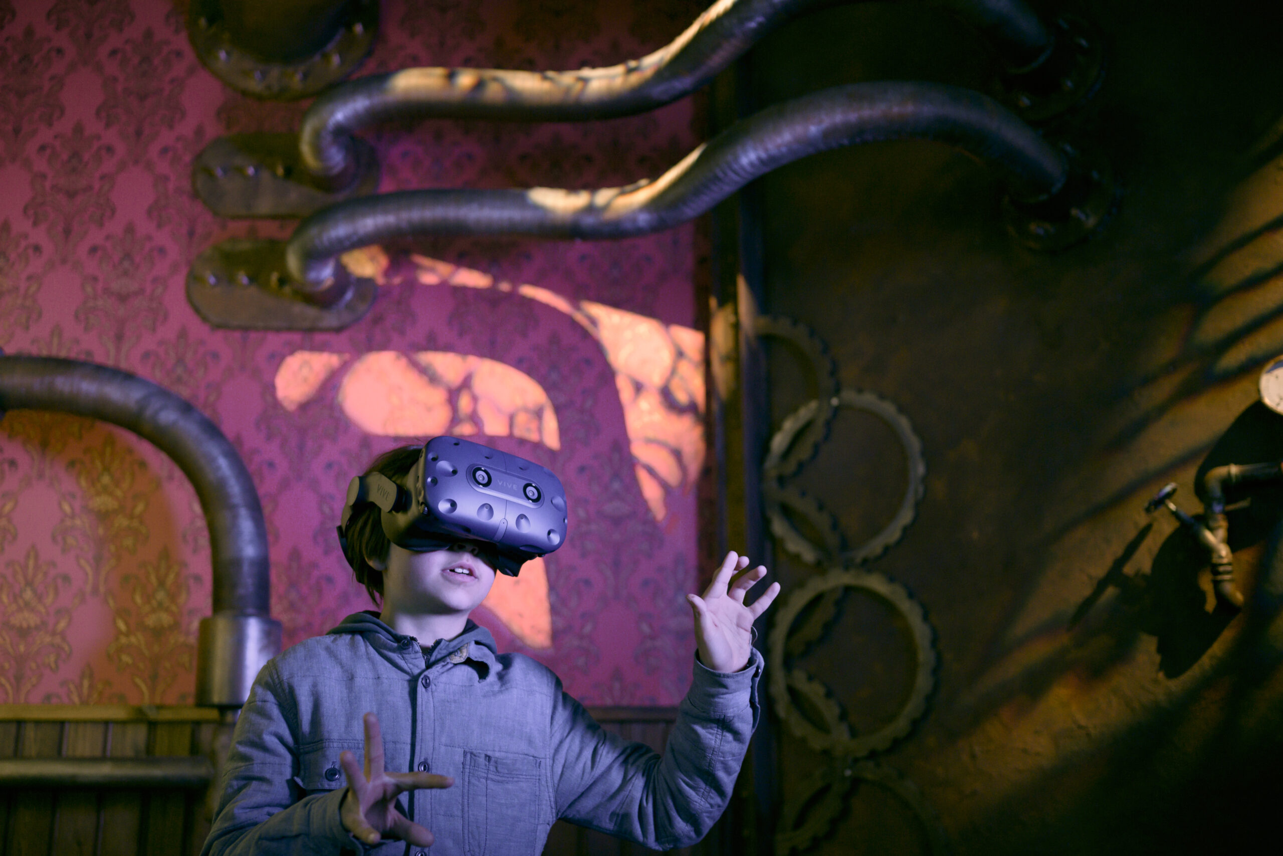 Poika kokeilee virtuaalilaseja Aikakone-näyttelyssä