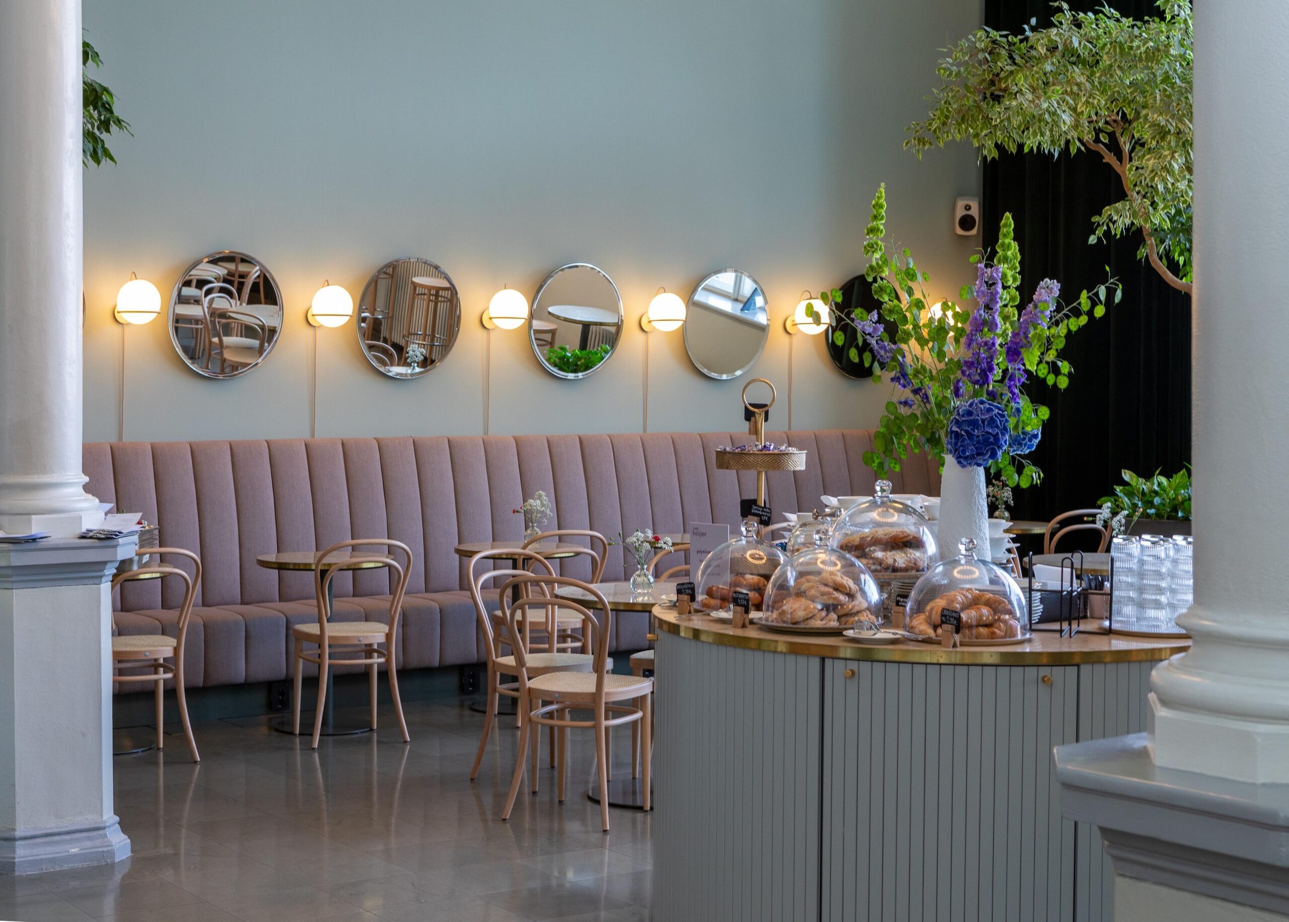 Café Höijerin sisätilat, jossa näkyy pöytiä, tuoleja sekä kahvilan tuotteita.