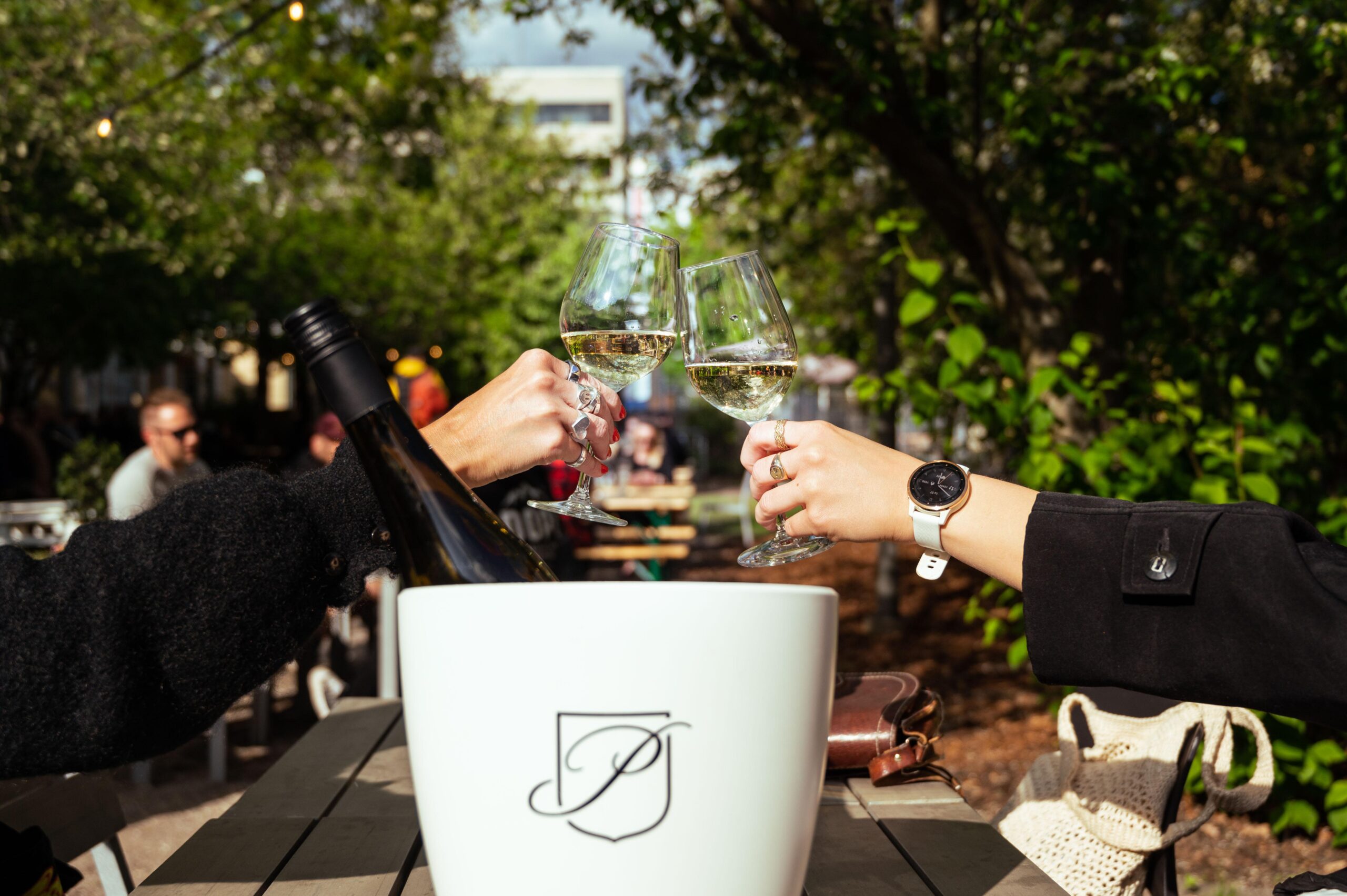 Korjaamon Baari & Keittiö. Kuvassa näkyy pöytä, jonka äärellä istuu ihmisiä juomalasit käsissään.