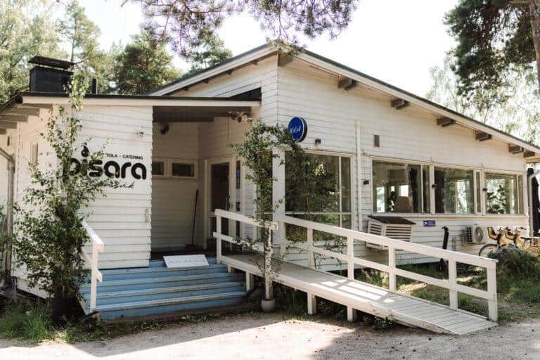 Restaurang Stansvik, utifrån sedd. En vit byggnad med träd bredvid.
