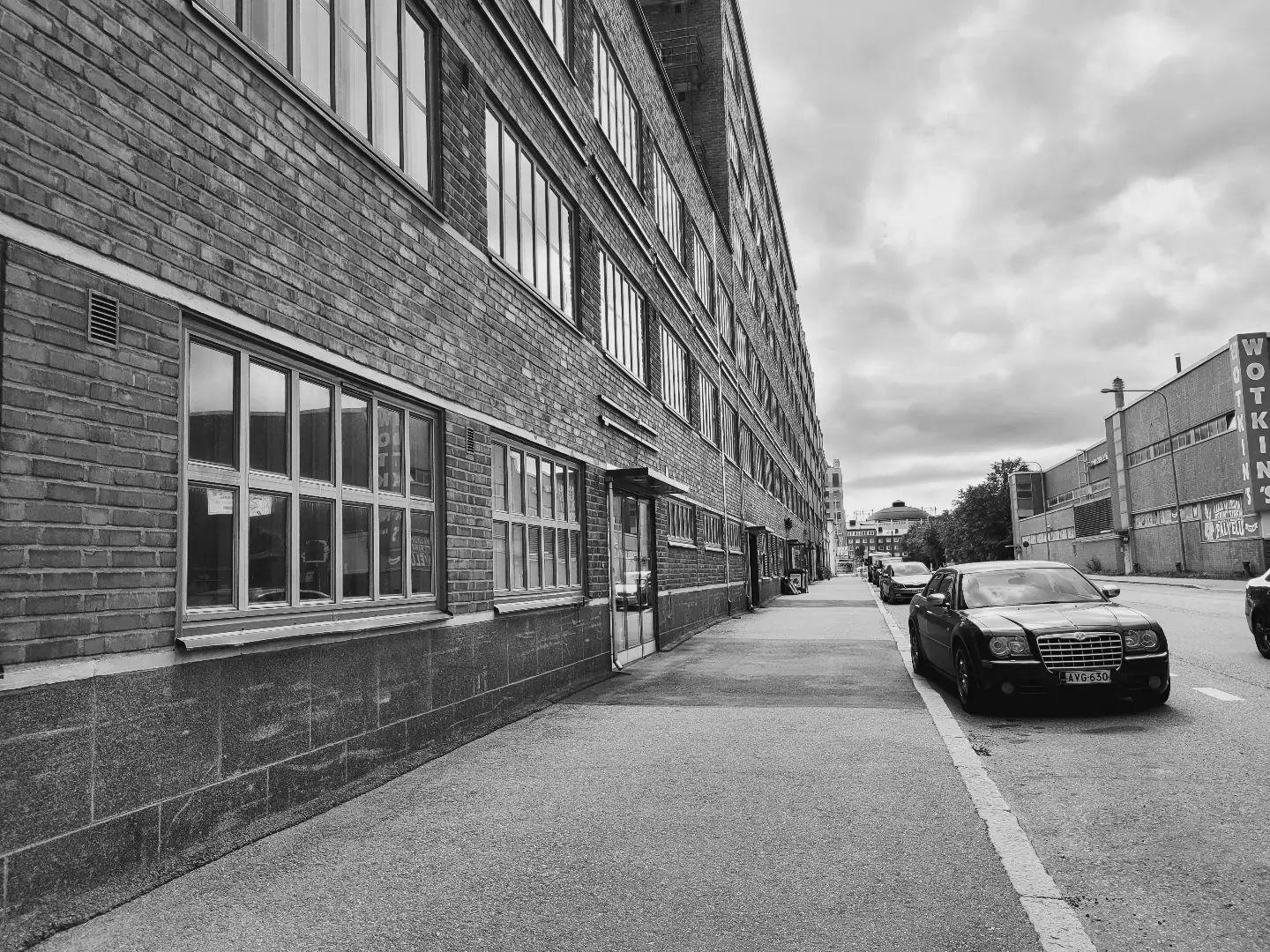 Mustavalkoinen kuva Ilves-Interiööristä, joka sijaitsee Vanha Talvitiellä katutasossa rappujen A ja B välissä. Rakennuksen vieressä näkyy autoja.