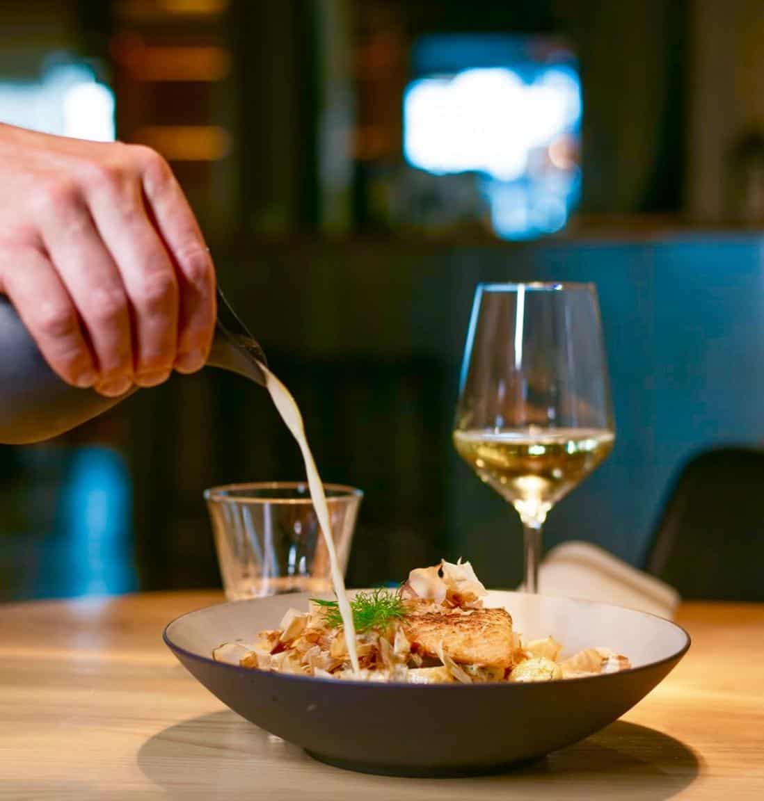 Fisken på Disken. A dish on the table, and a wine glass in the background.
