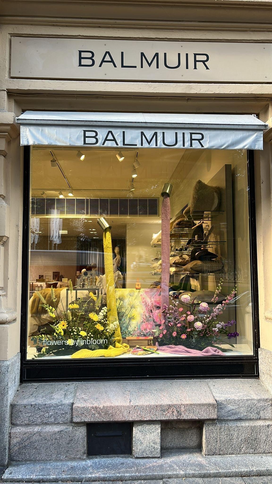 Balmuir Brand Store photographed on the outside. The name of the shop with black letters above the shop's window.