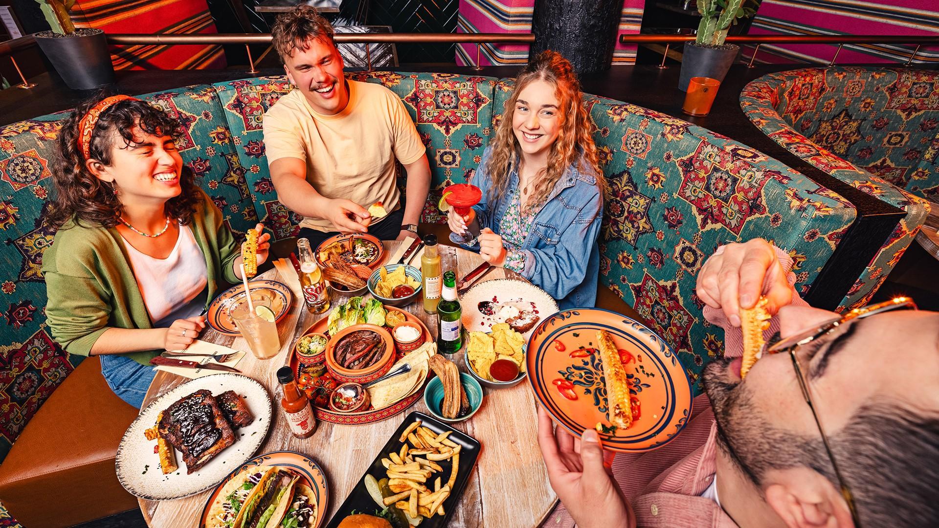 Amarillo Tikkurila, människor runt ett bord med olika maträtter.