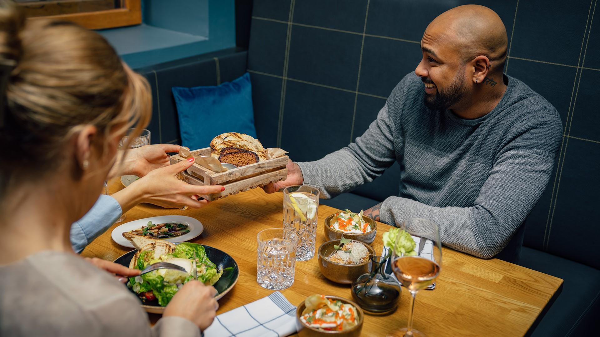 Bistro Gimis, people sitting around a table with dishes and drinks.