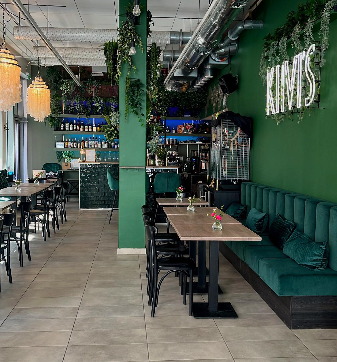 Kiivi's Café & Bar from inside. Tables, chairs and a green wall.