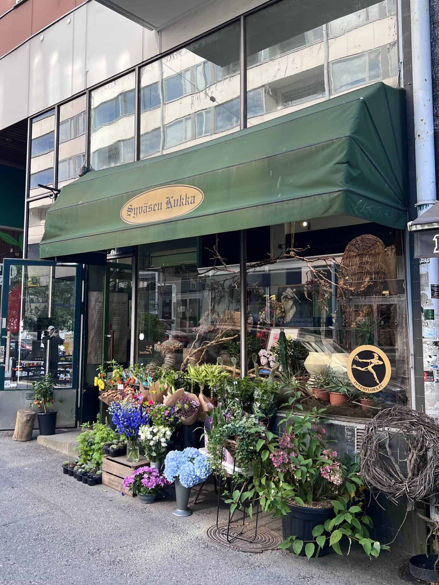 Syväsen Kukka, as seen from the outside. The shop's entrance, next to which there are plants and flowers.
