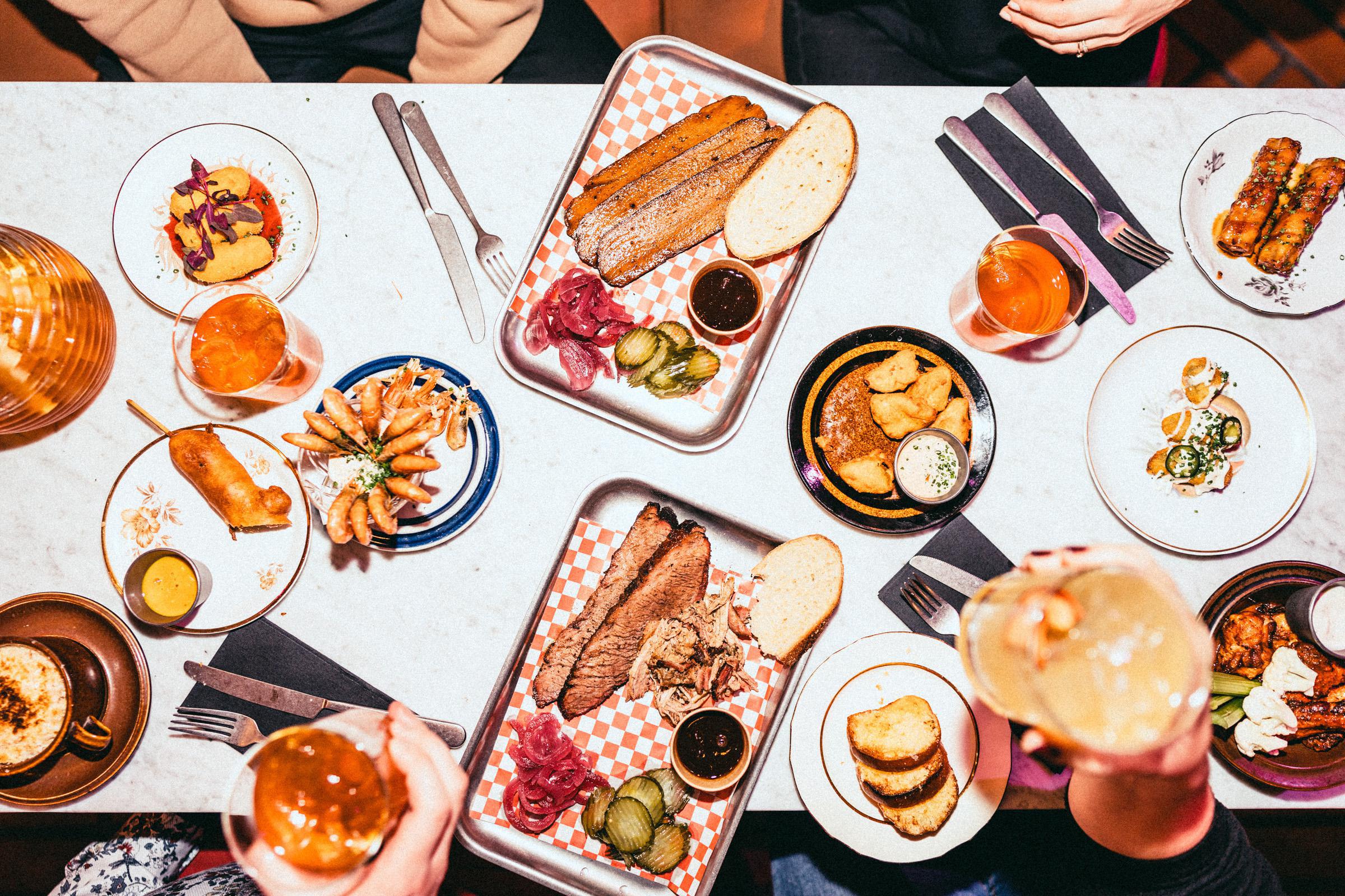 Pöydällä amerikkalaistyylistä barbequeta ja värikkäitä cocktaileja.