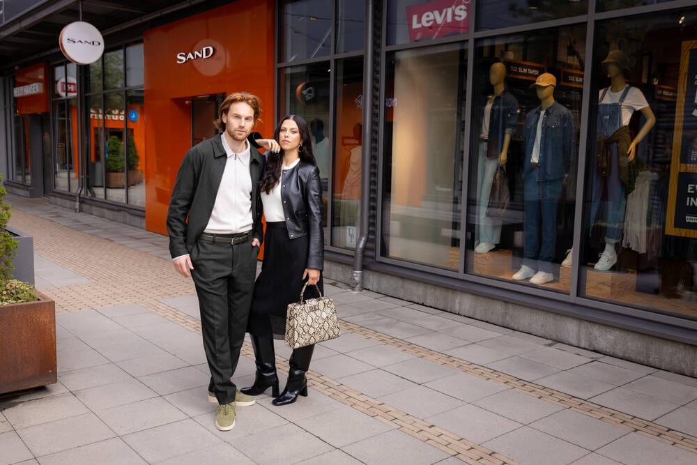 A man and a woman shopping at Helsinki Outlet outside the Sand and Levi’s stores.