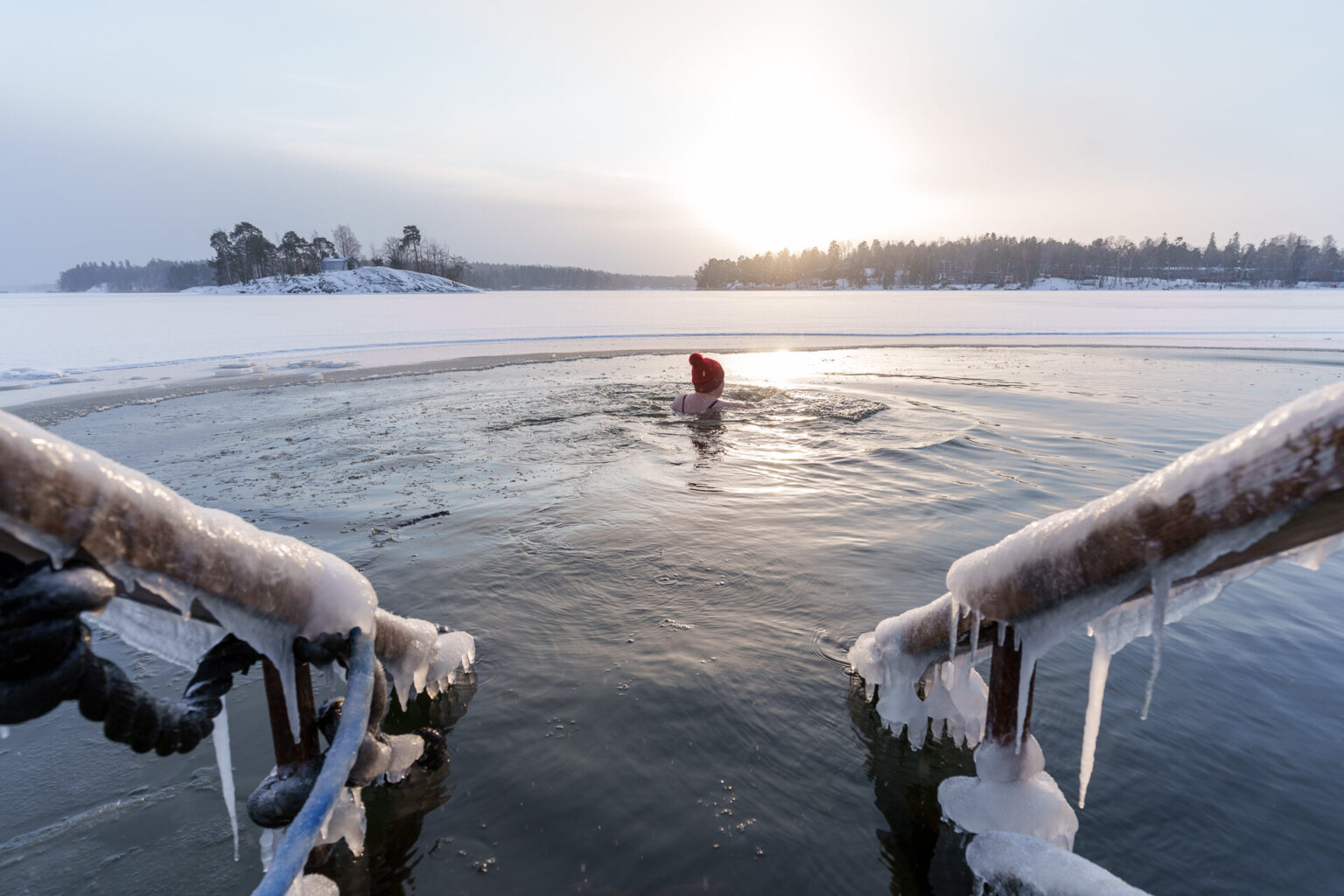 Woman winter swimming in the sunset in Helsinki