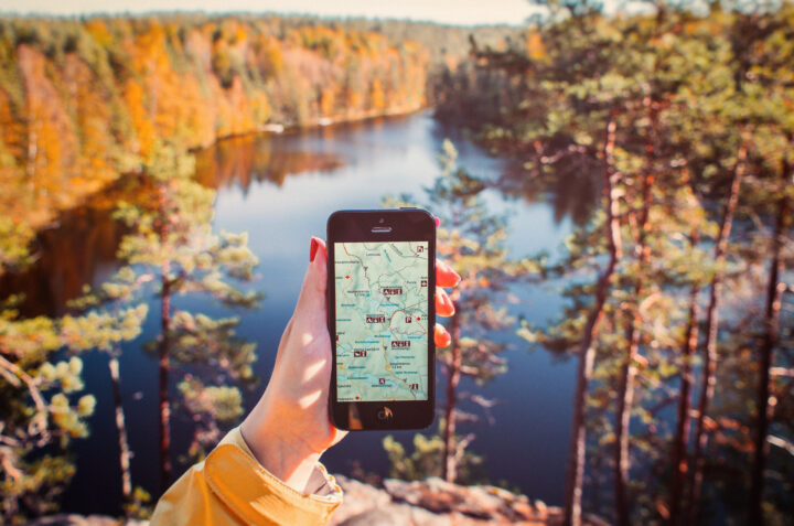 Nuuksio national park in Helsinki and woman's hand holding a mobile phone