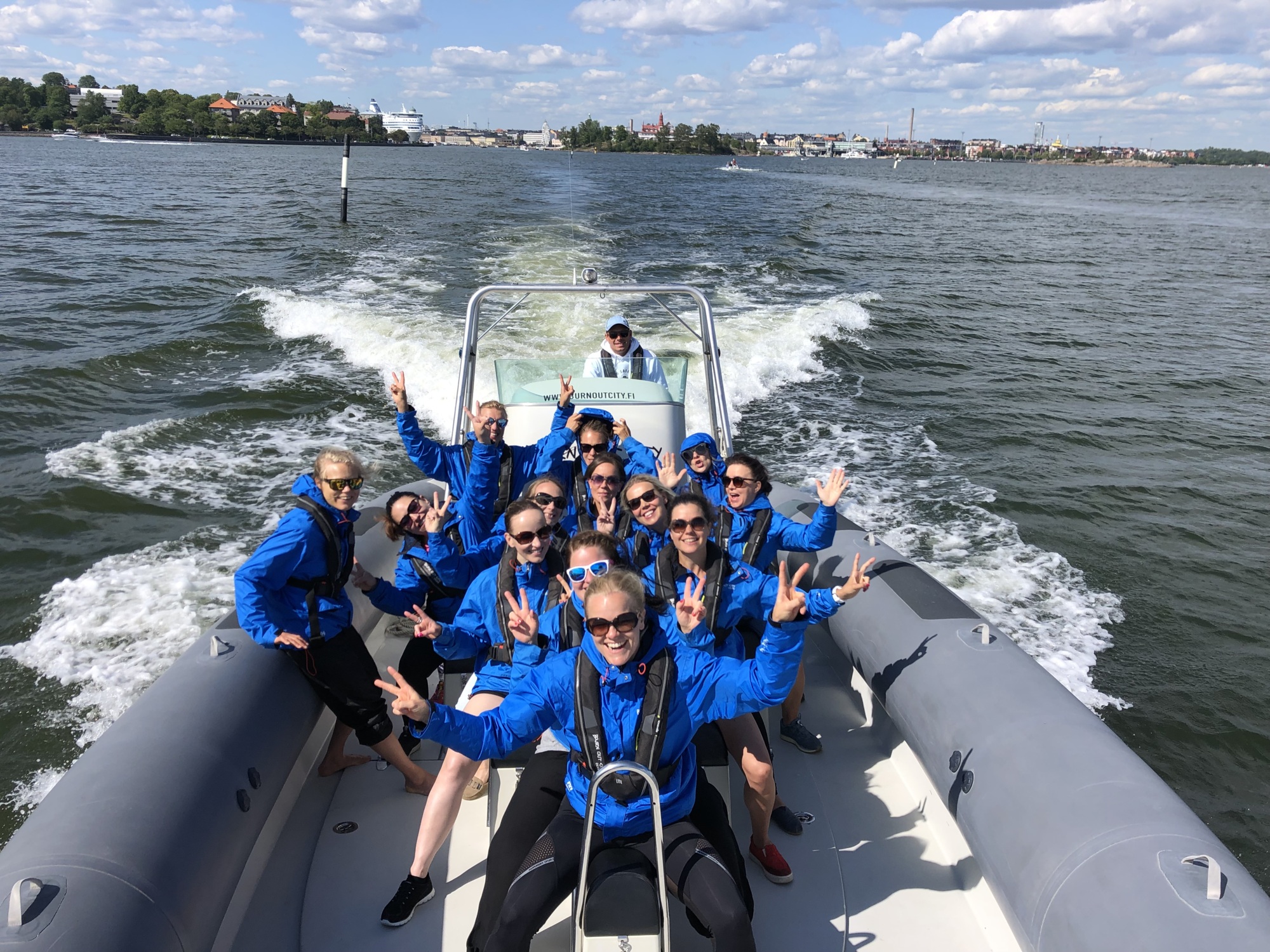 Group of people in blue jackets on a boat in the sea