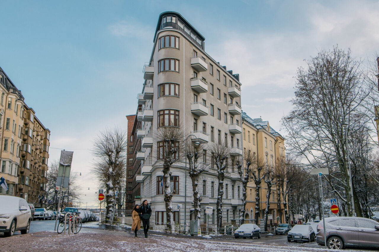 Couple passing the flat-iron house in Eira district, part of Helsinki Design District