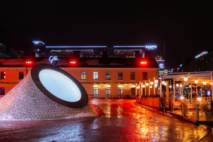 Kamppi Helsinki at night: illuminated funnel art installation and wet street