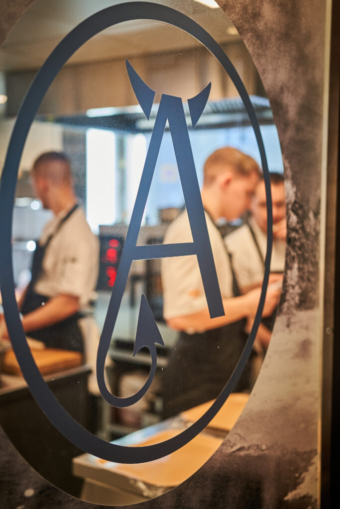 Chefs working behind a glass logo at Finnjavel Salon