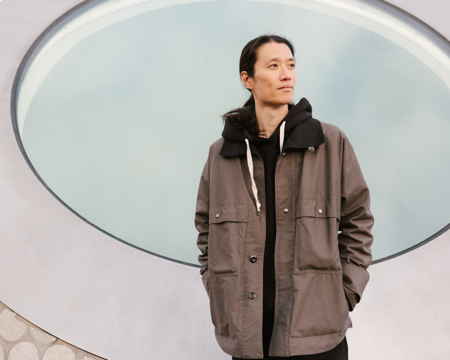 a man standing in front of a circular window
