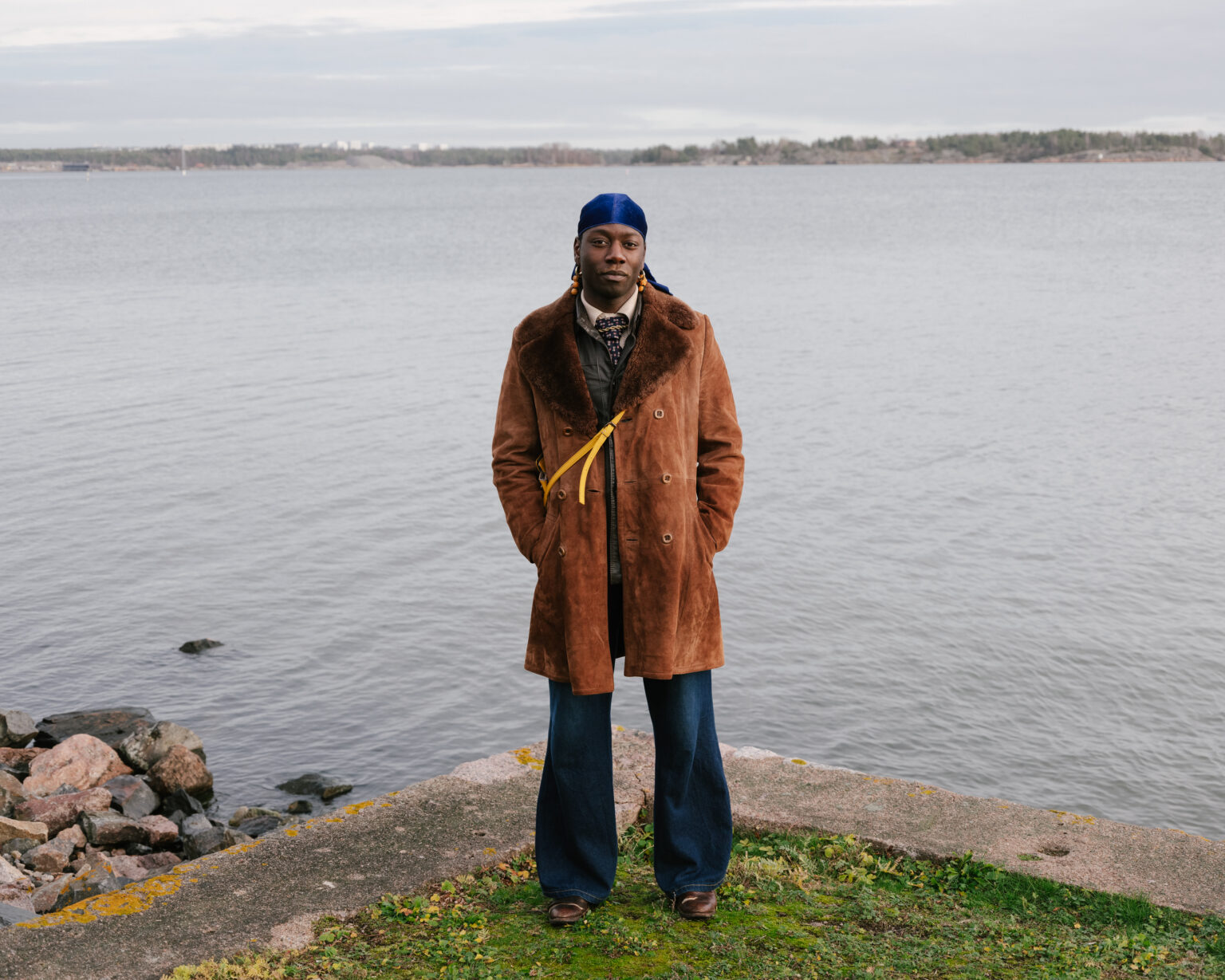 a man standing on a rock ledge by water