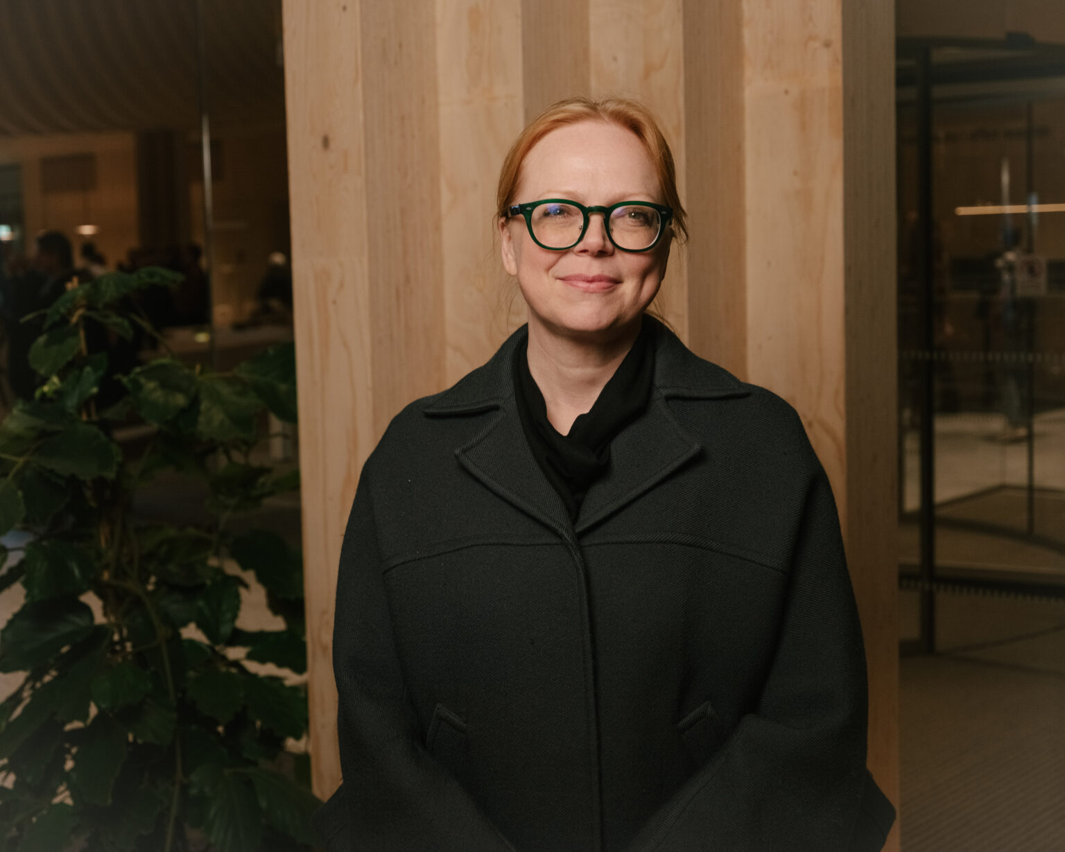 a woman wearing glasses and a black coat