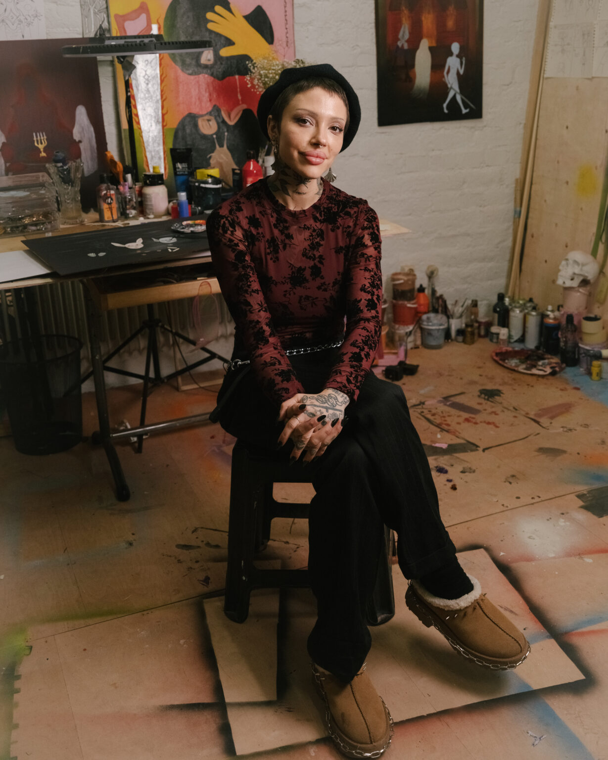 a woman sitting on a stool in a studio
