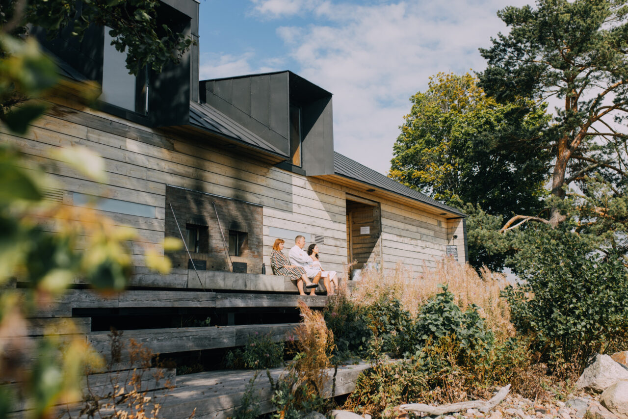 a group of people sitting on a porch outside of a house