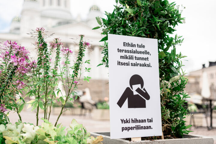 a sign with a person covering their face