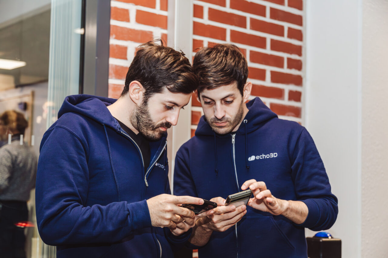 two men looking at a cellphone