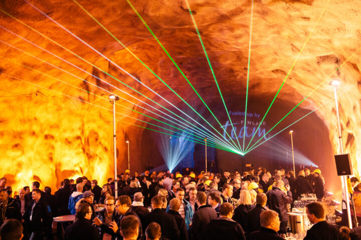 Crowd gathered in a tunnel with laser lights, text "Fueled up by Team Finland