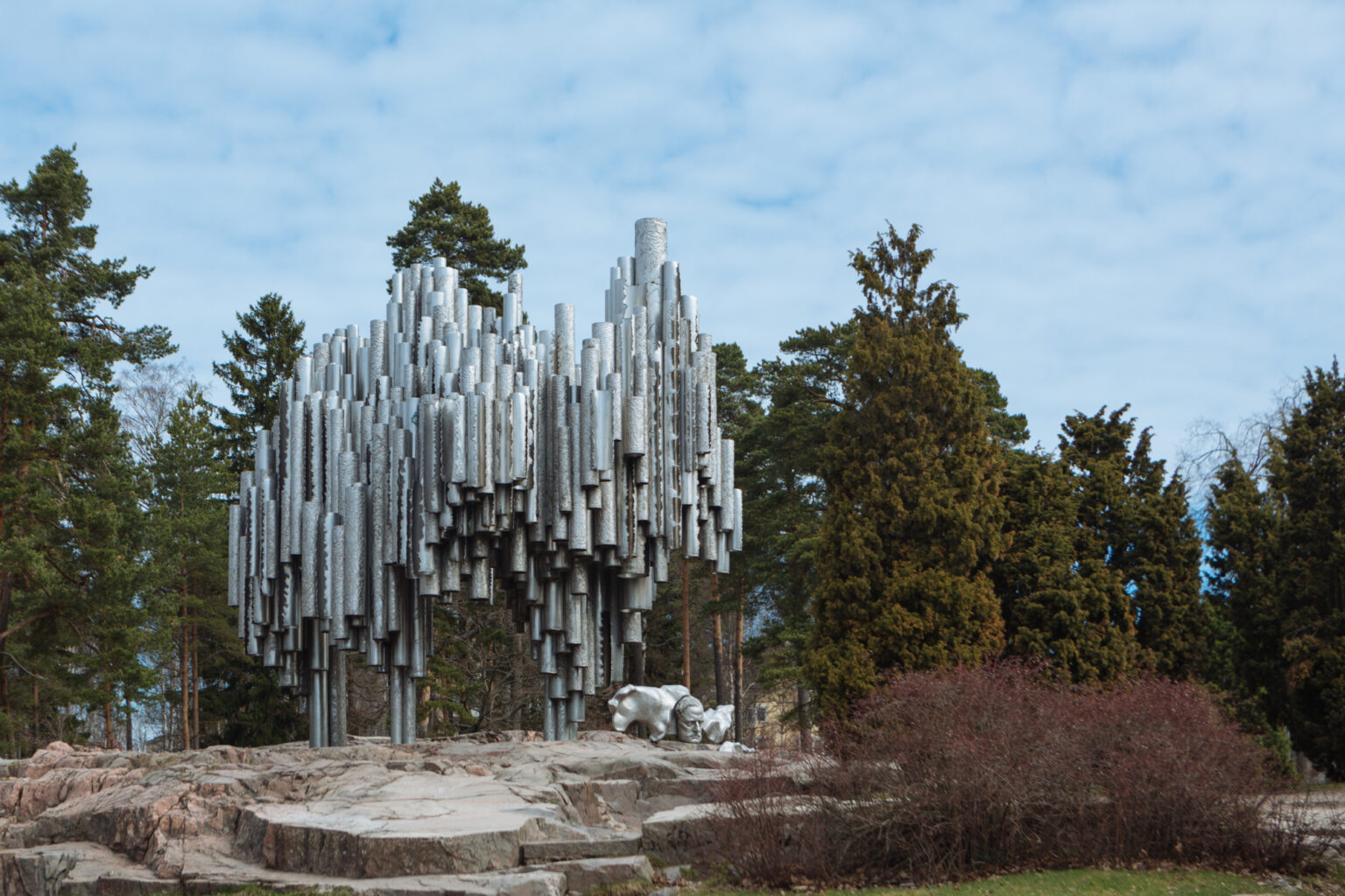 Sibelius Monument in Helsinki, Finland, with pipe-like sculptures and surrounding trees.
