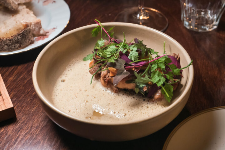 Gourmet dish of finely chopped meat, herbs, and foam in a bowl