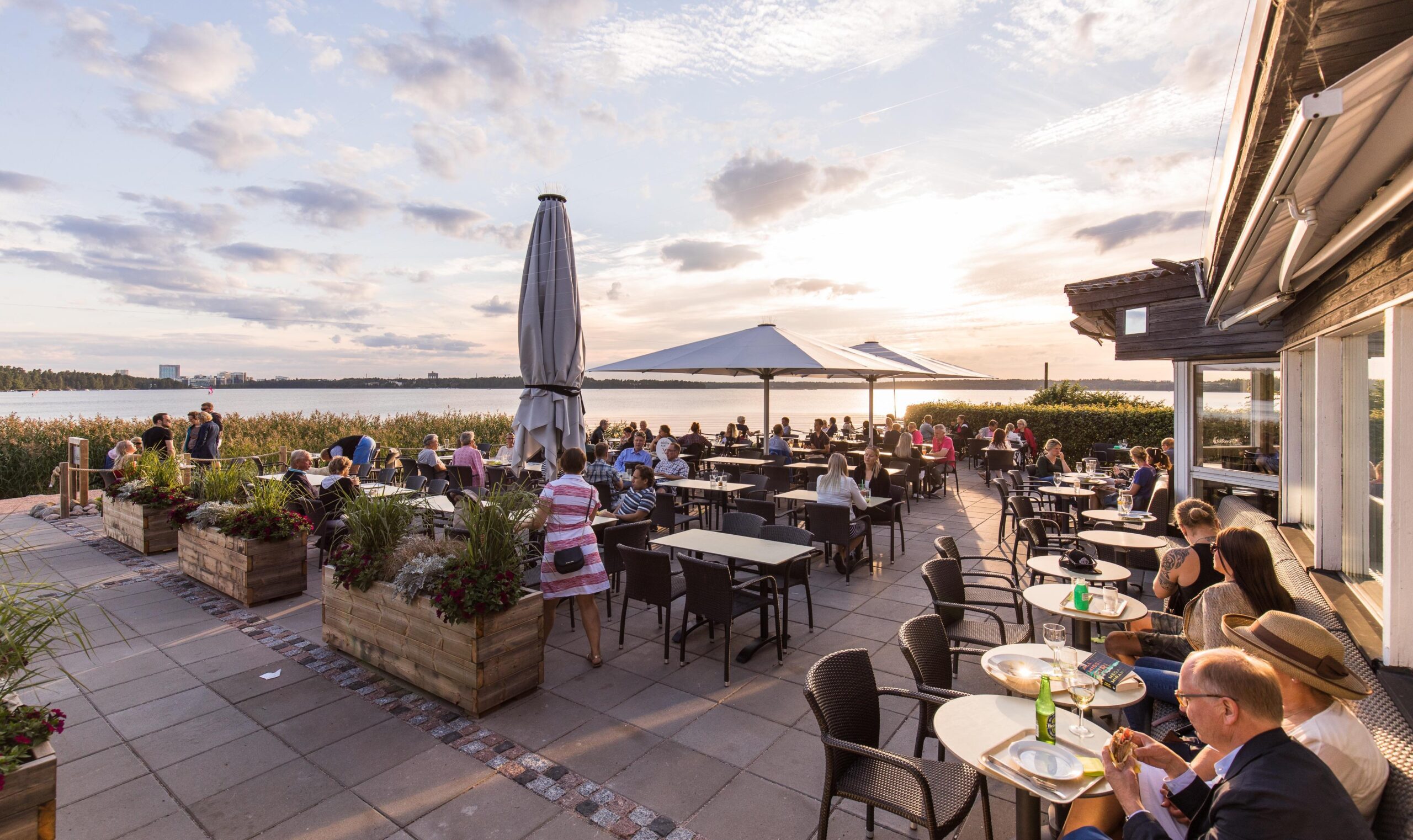 Café Torpanrantas uteservering, där det sitter människor. I bakgrunden syns havet.