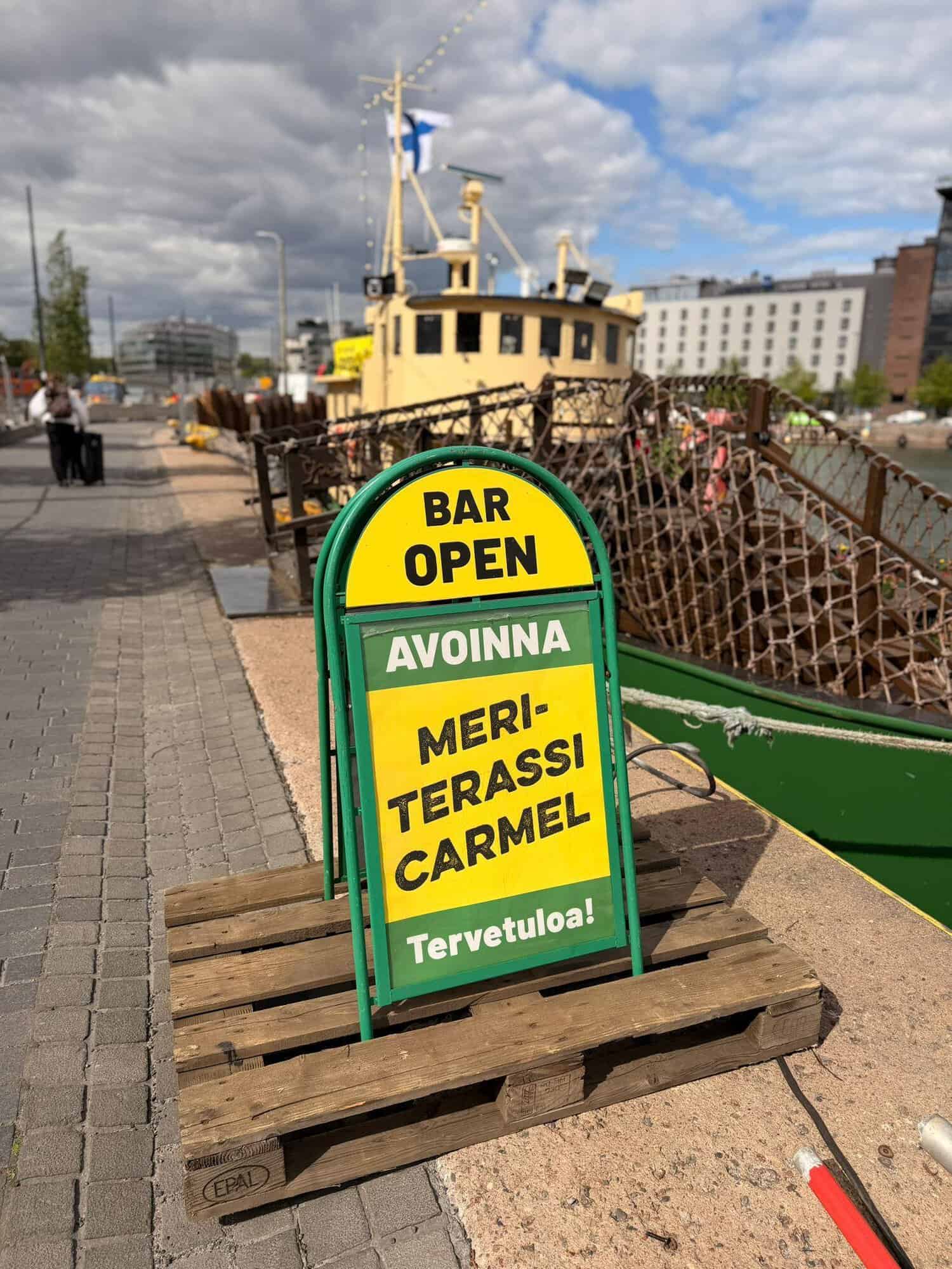Meriterassi Carmel Jätkäsaaren laiturissa. Kuvassa näkyy kyltti, ja sen taustalla laiva.
