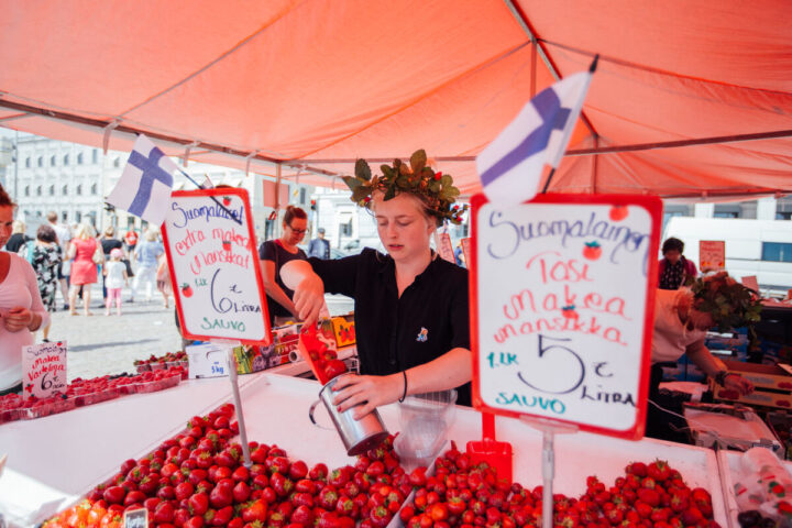a woman selling strawberries at a market
