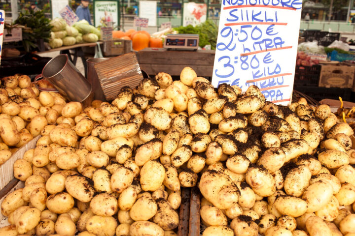 a pile of seasonal food potatoes with dirt on it at Hakaniemi Market