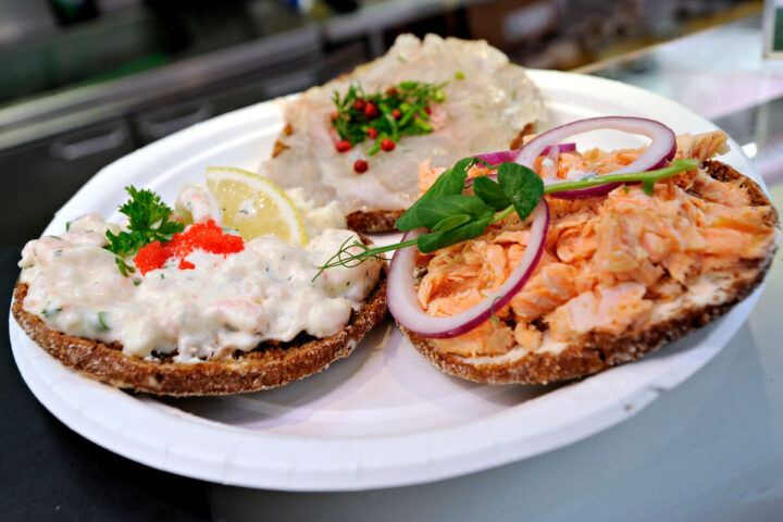 a plate of different types of Baltic herring on bread on a table