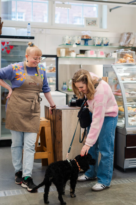 a woman petting a dog in a Helsinki market hall