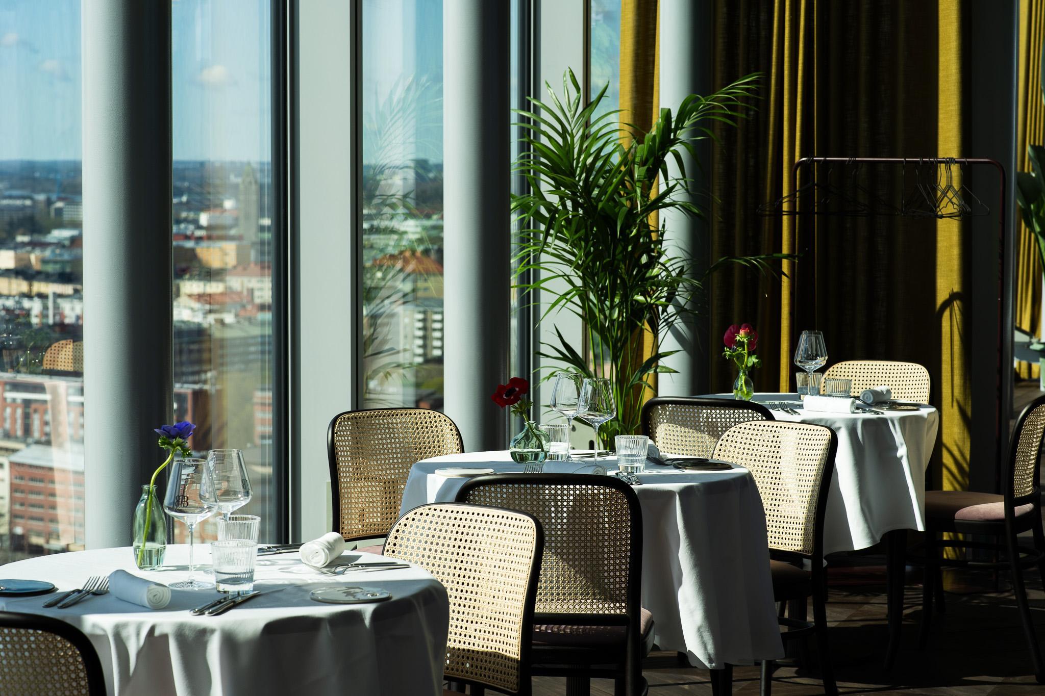 BISOUBISOU bar & brasserie, photographed from the inside. Tables can be seen in the dining area, and big windows.