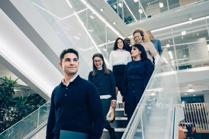 Group of professionals ascending staircase together.