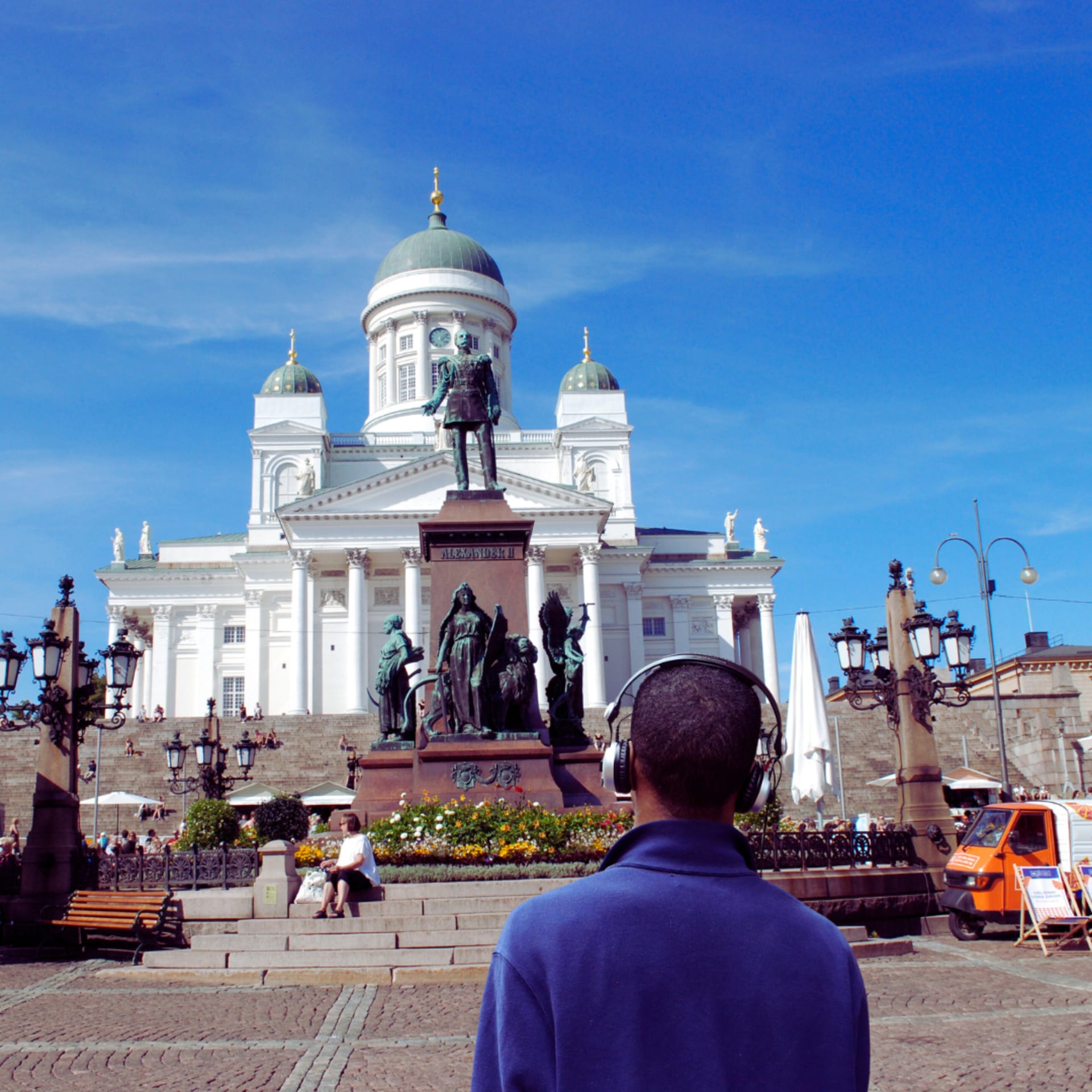 Man listening to audio tour while looking at Helsinki Cathedral on Helsinki Senate Square