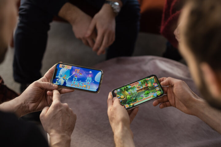 Two people playing mobile games together.