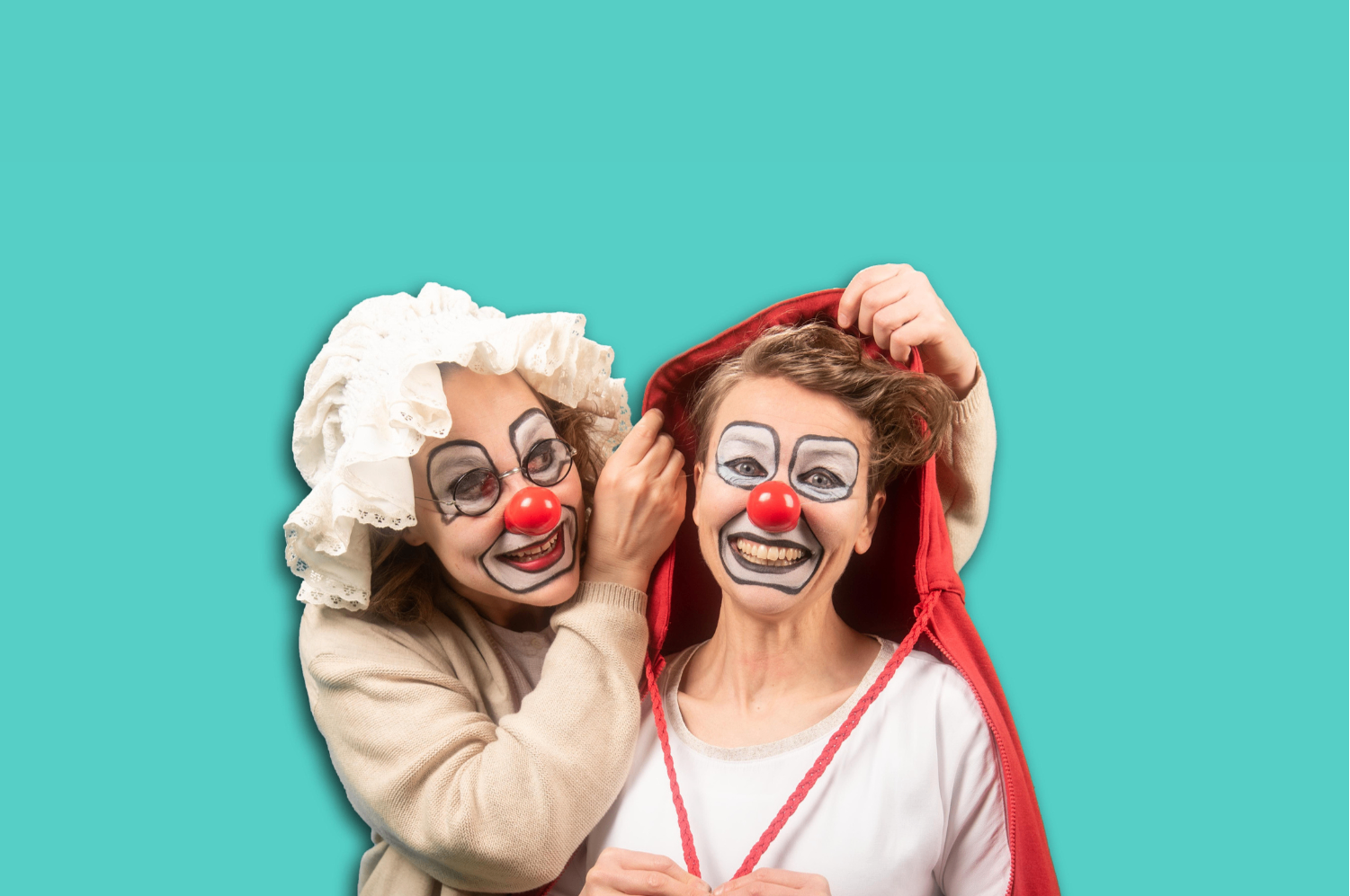 Isoäiti-klovni ja Punahilkka-klovni hymyilevät.