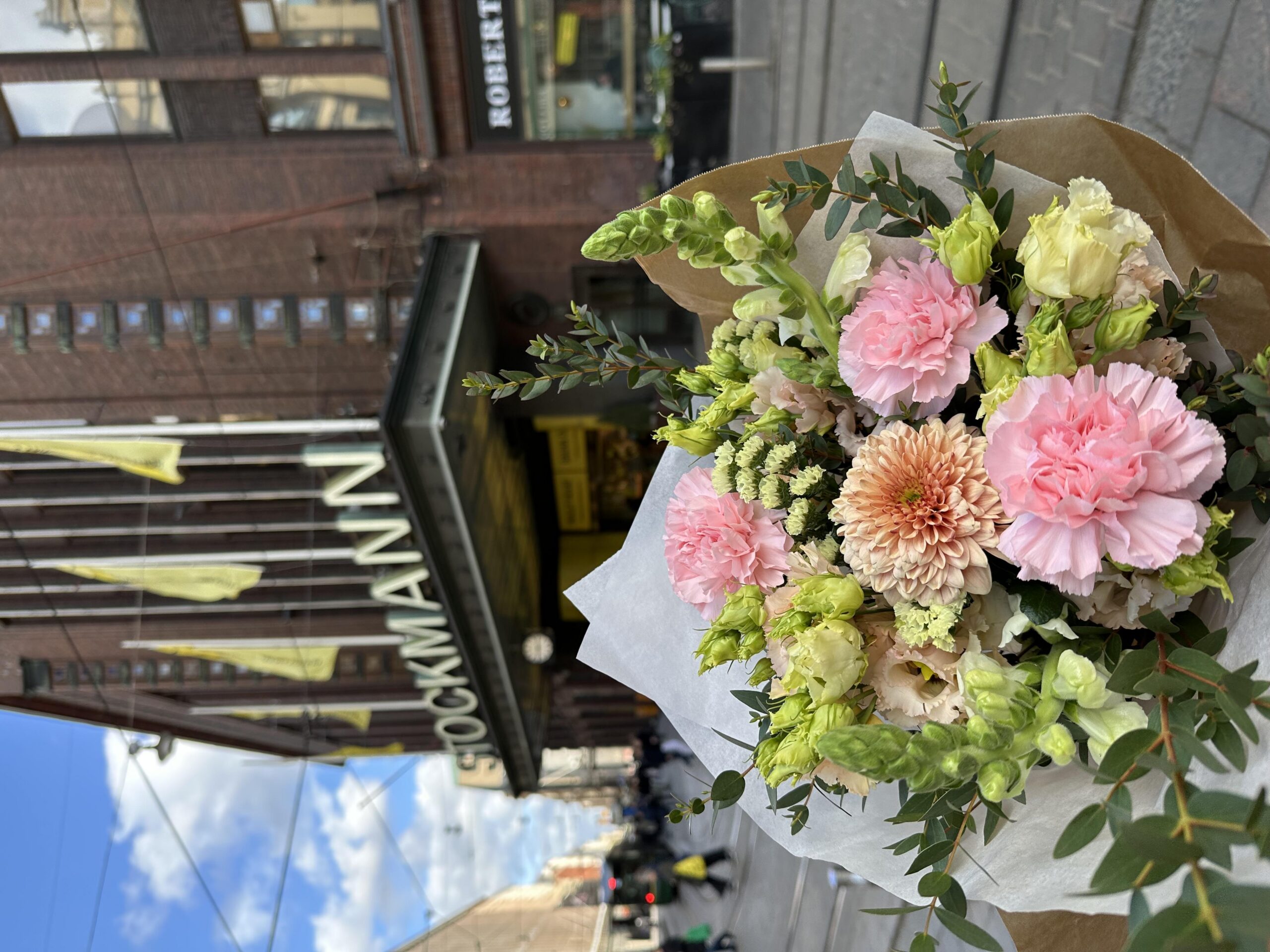 A flower bouquet, with a department store in the background.