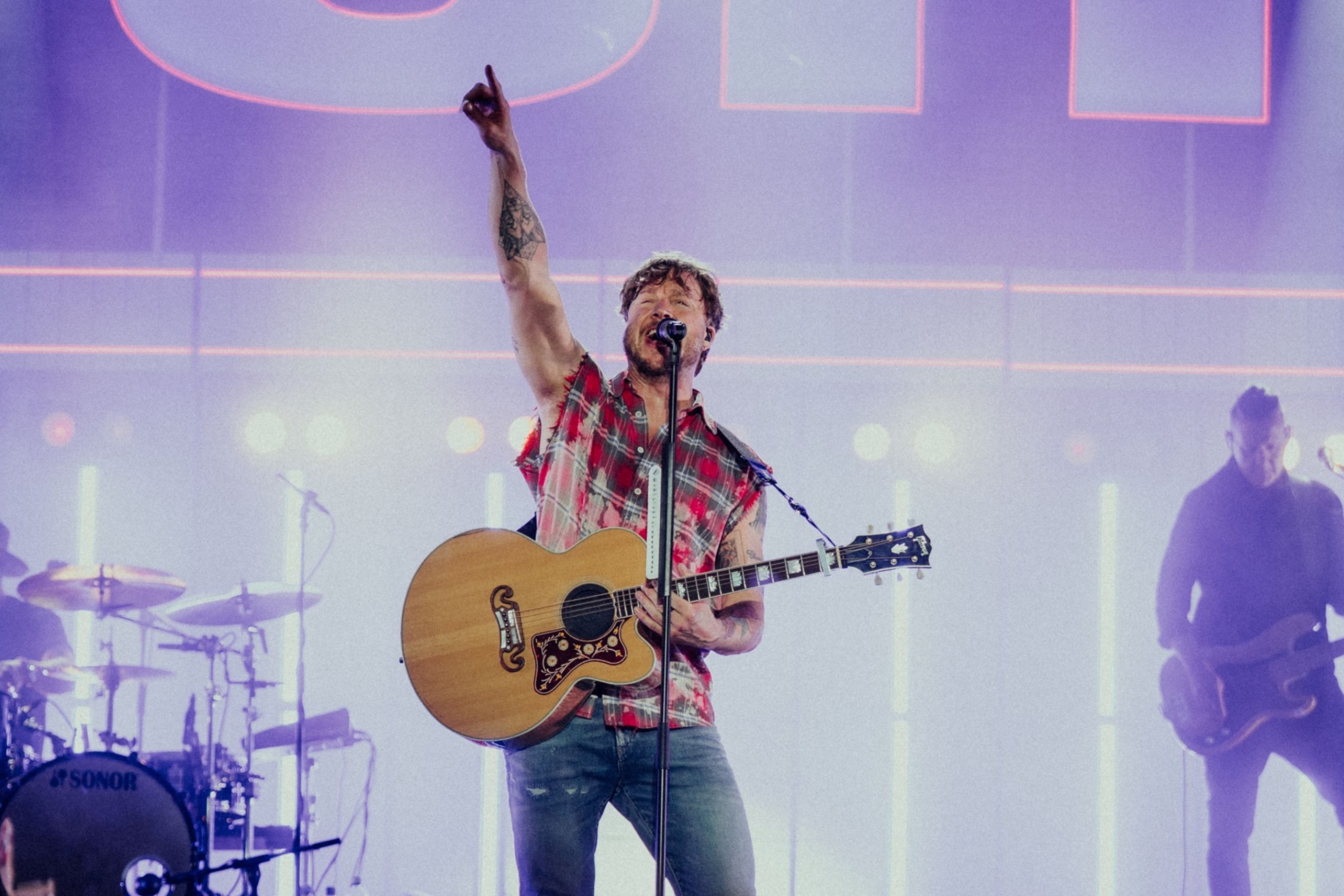 Mies laulaa ja soittaa kitaraa