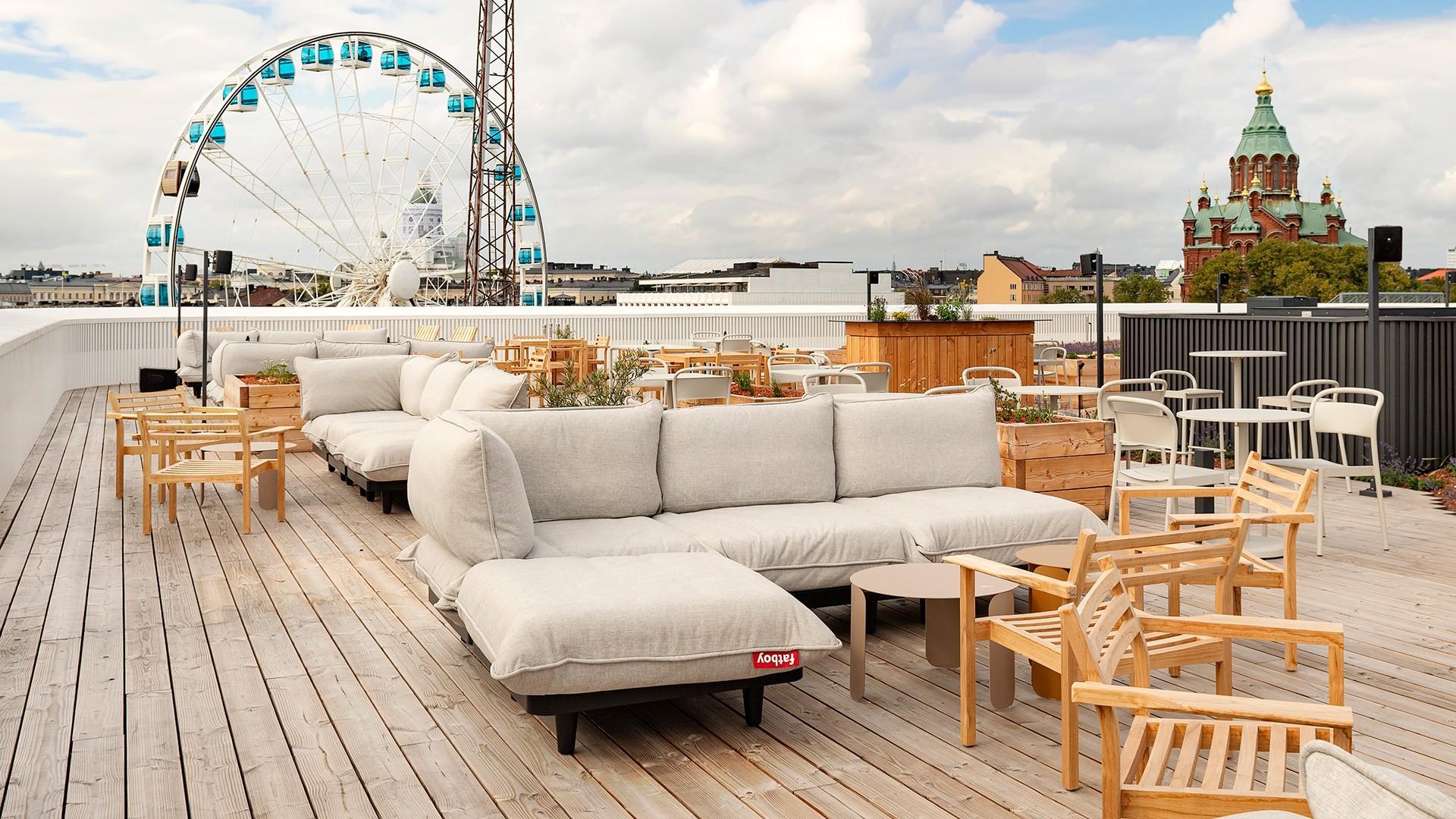 Rooftop Bar Humu, där det finns en takterrass. På taket finns soffor och stolar. I bakgrunden syns ett pariserljul och två kyrkor.