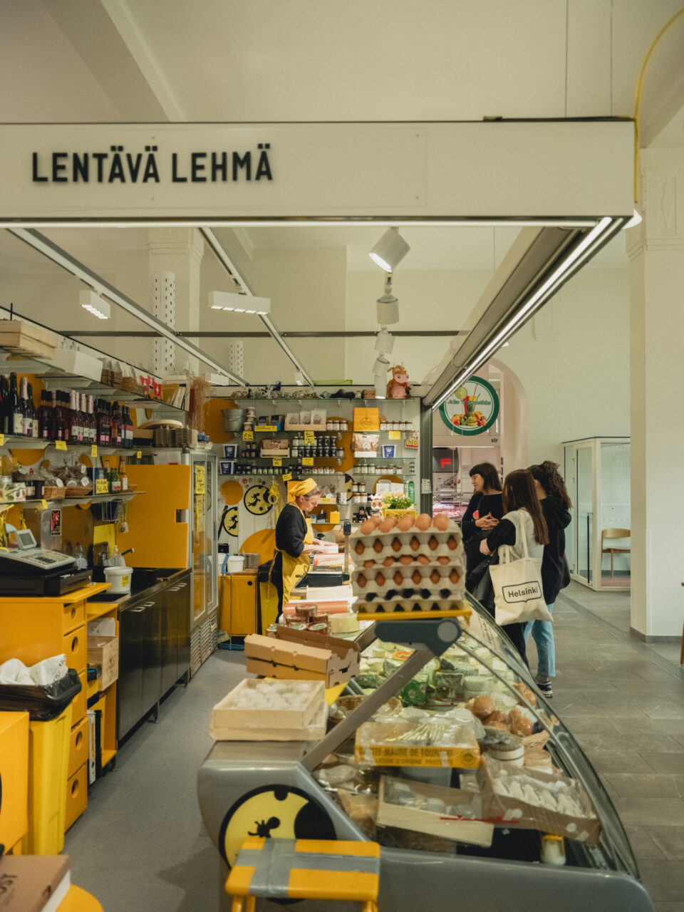 A group of woman order cheese at the counter of Lentävä Lehmä