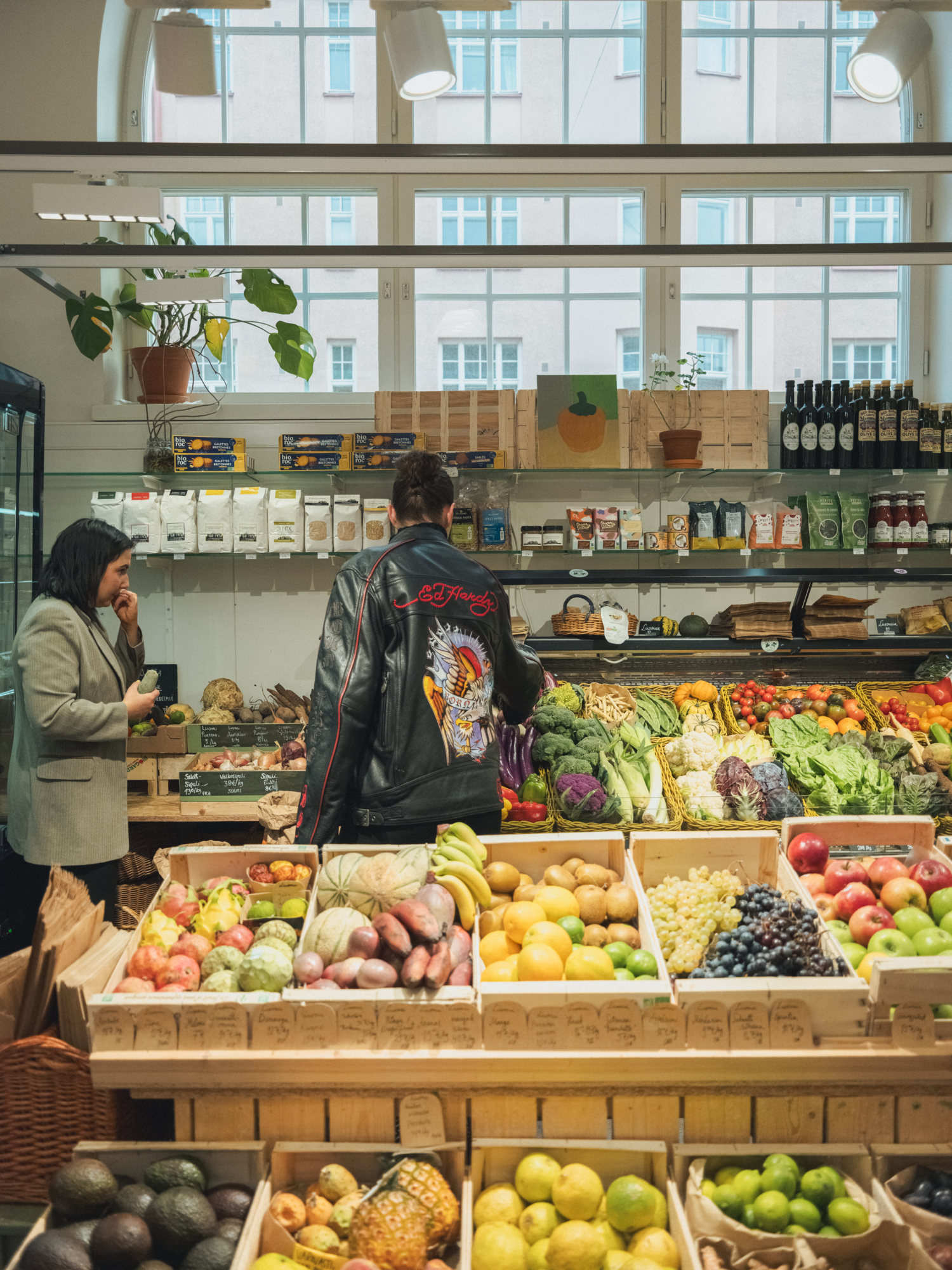 Two women brows the vegetables at Kuurnan Kasvispuoti