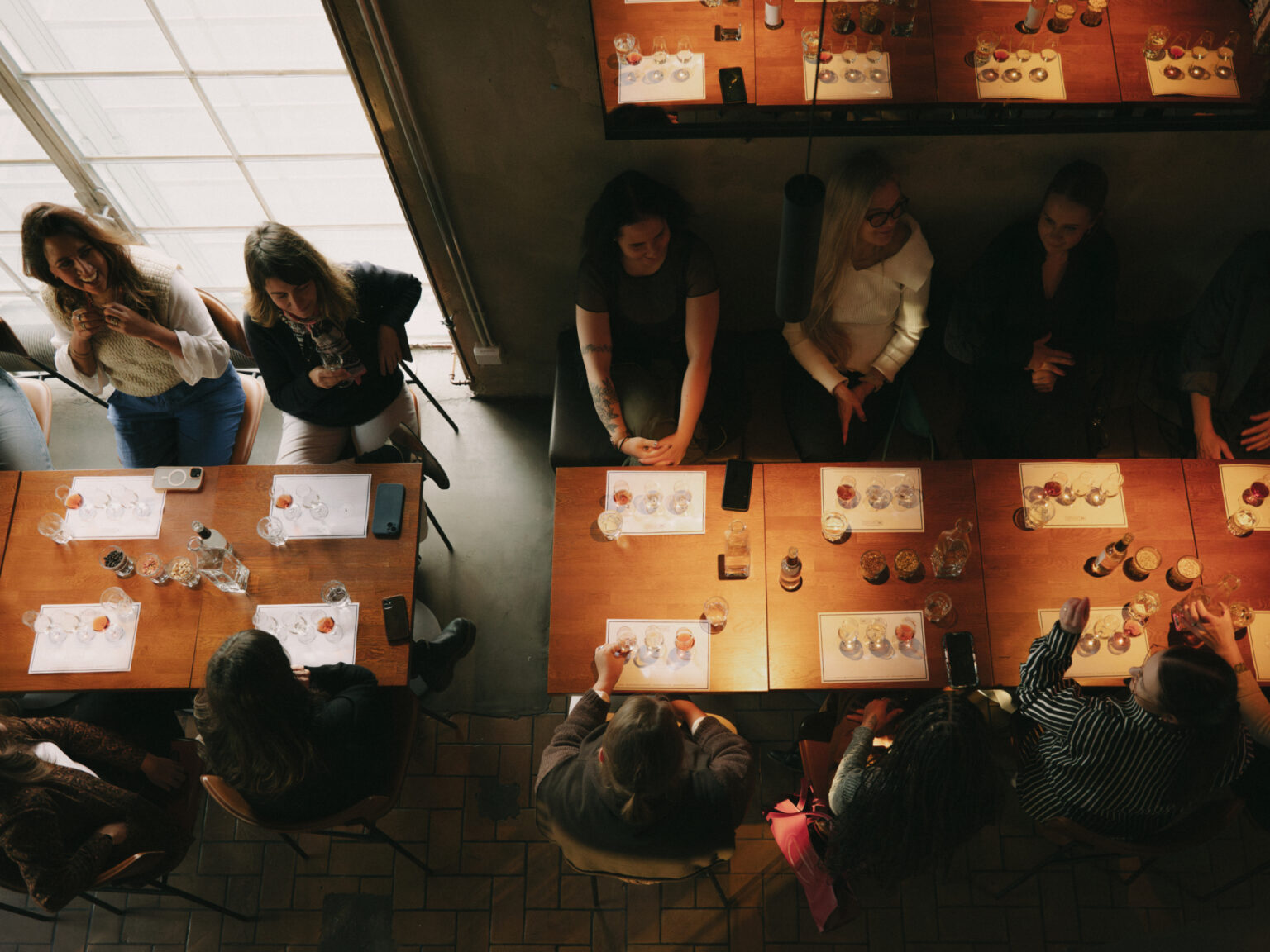 People enjoying a tasting experience at a distillery with drinks and glasses