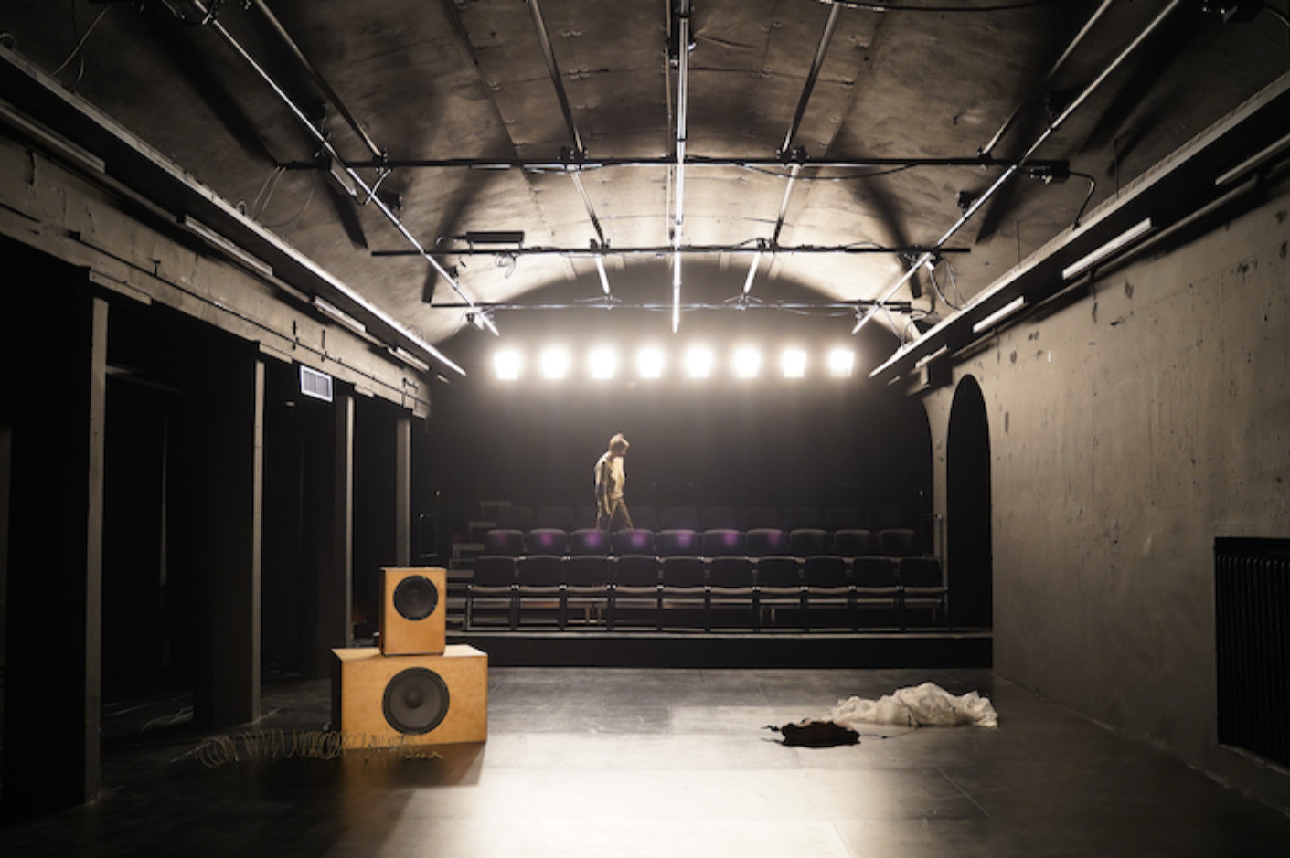 tyhjä teatterisali, isoja kaiuttimia, ihminen katsomossa
