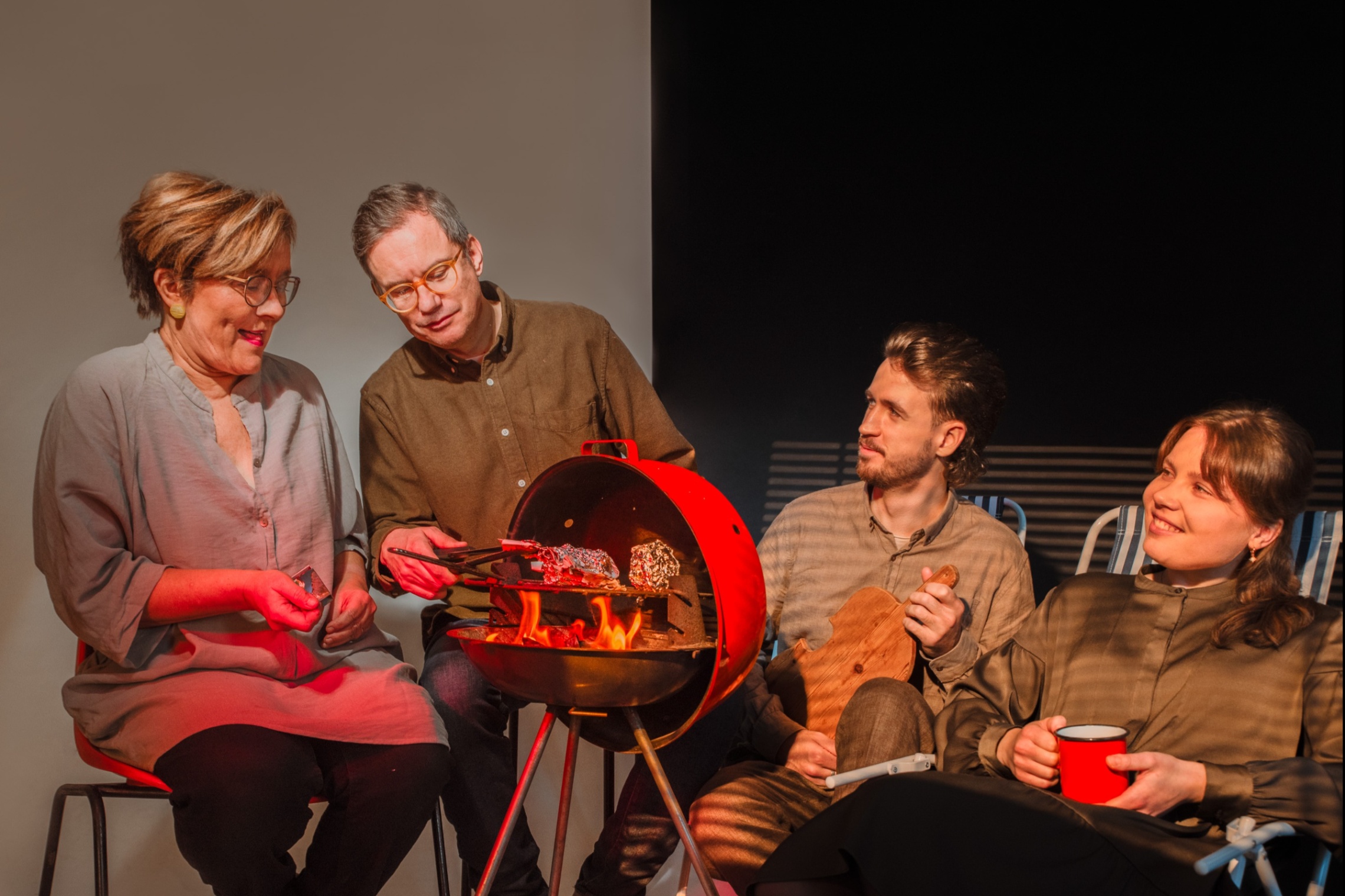 neljä ihmistä istuu grillin ääressä