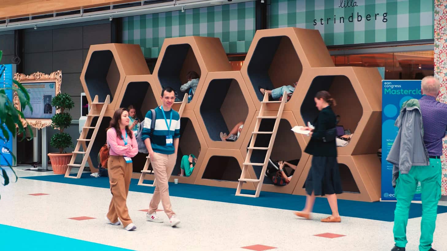 People relax in honeycomb-shaped pods at a conference, with "lilla strindberg" visible.