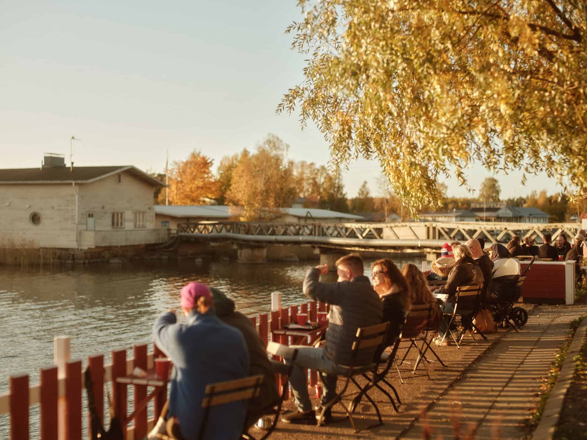 People sitting in the autumnal sun by Cafe Regatta in Töölö, Helsinki